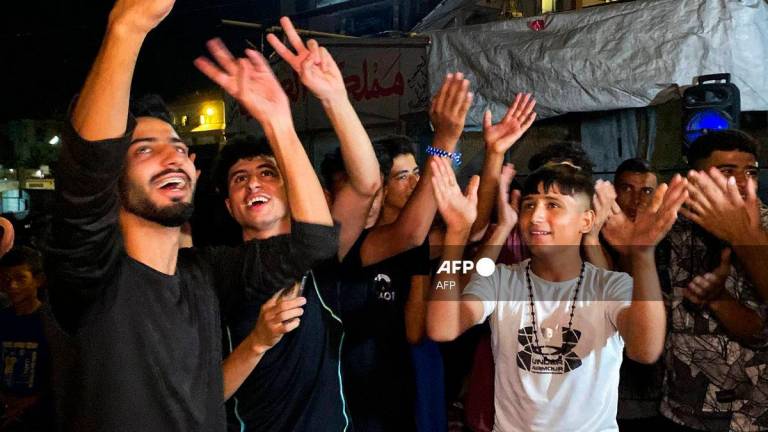 Palestinians celebrate in Khan Yunis on October 9, 2025, following news of a new Gaza ceasefire deal. US President Donald Trump announced that Israel and Hamas have agreed to the first phase of a ceasefire in Gaza, after days of indirect talks in Egypt. (Photo by AFP)