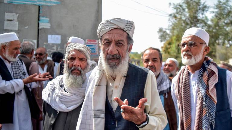 In this photograph taken on August 25, 2025, an Afghan retiree, Abdul Sabir (C), speaks during an interview with AFP outside a government building in Kabul. - Bais Yusufi / AFP