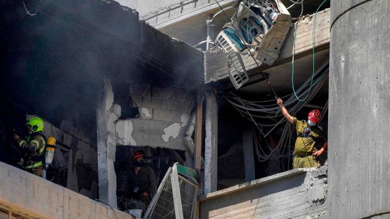 First responders inspect a heavily-damaged building at Soroka Hospital in Beersheba in southern Israel following an Iranian missile attack on June 19, 2025. A hospital in southern Israel was hit during a barrage of “dozens” of Iranian missiles on June 19, officials said, while another impact was reported by emergency services in the Tel Aviv area. - MAYA LEVIN / AFP