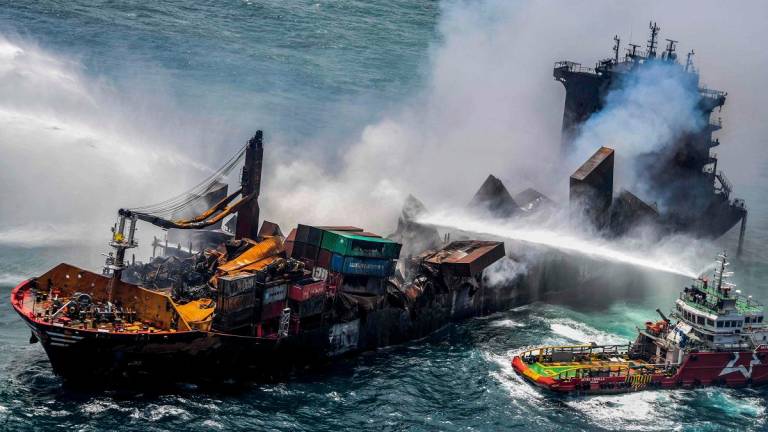 (FILES) This handout photograph taken and released by the Sri Lanka Air Force on May 30, 2021 shows smoke billowing from the Singapore-registered container ship MV X-Press Pearl, which has been burning for the eleventh consecutive day as vessels try to douse off the fire, in the sea off Sri Lanka’s Colombo Harbour, in Colombo. - SRI LANKA AIR FORCE / AFP