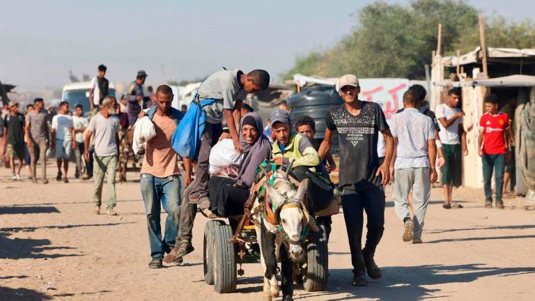 Palestinians make their way in the Mawasi area of Rafah on July 24, 2025, after receiving humanitarian aid from an aid distribution point in the southern Gaza Strip - AFPPix