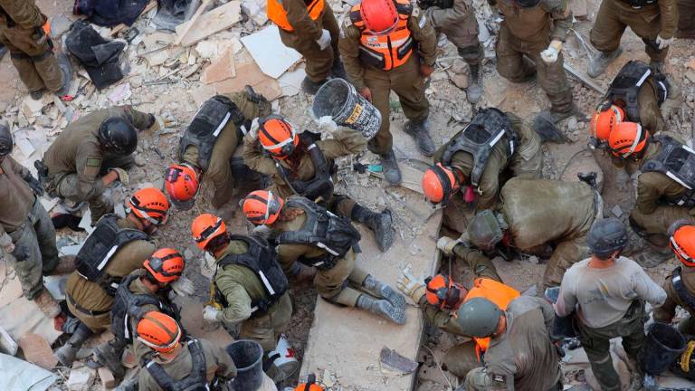 Israeli rescuers search through the rubble at the site of an overnight Iranian missile strike in Bat Yam on June 15, 2025. (Photo by GIL COHEN-MAGEN / AFP)