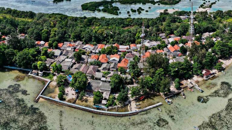 (FILES) In this aerial picture taken on February 22, 2023, a concrete embankment, used to stem rising sea levels, is seen around part of Pari island in the Thousand Islands cluster. (Photo by Bay ISMOYO / AFP)