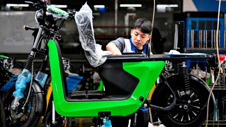 A worker assembles electric motorbikes at the Selex factory in Hanoi © Nhac NGUYEN / AFP