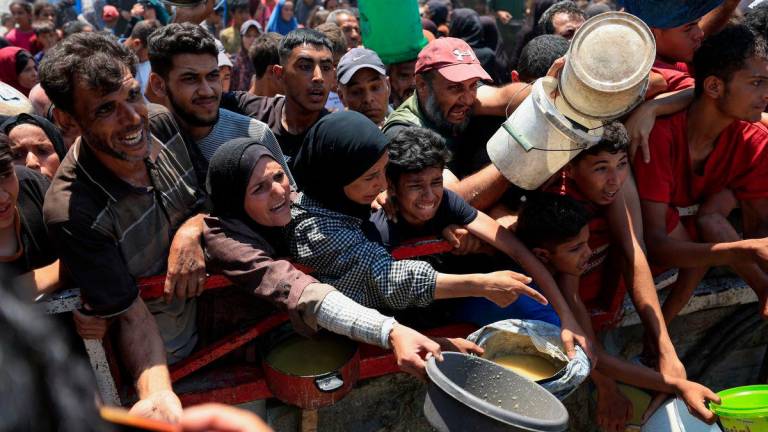Palestinians gather to receive food from a charity kitchen, amid a hunger crisis, in Gaza City, July 25, 2025. - REUTERSPIX