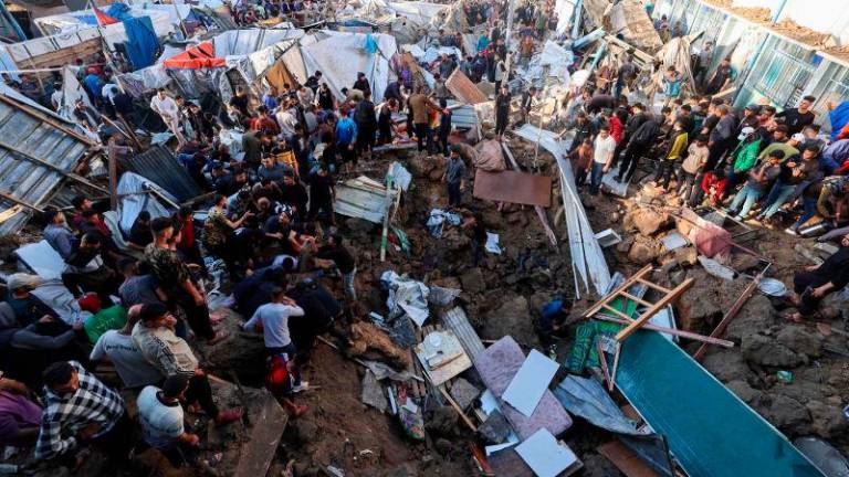 People search for survivors in a crater at the site of an Israeli strike at a UNWRA school housing displaced Palestinians at the Bureij camp for refugees in the central Gaza Strip on May 6, 2025.. AFPpix