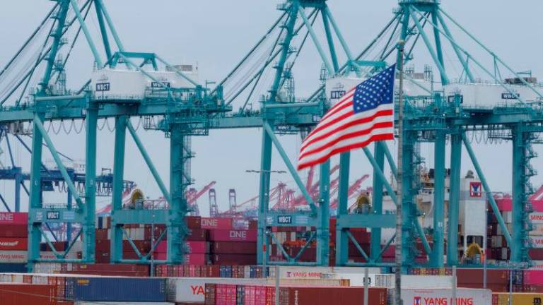 A U.S. flag flutters near shipping containers at the Port of Los Angeles, in San Pedro, California, U.S., May 1, 2025. REUTERSpix