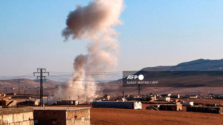 A plume of smoke erupts from bombardment amidst ongoing battles between the Turkish-backed Syrian National Army faction and the Kurdish-led Syrian Democratic Forces (SDF) at a position near the Tishrin Dam in the vicinity of Manbij, in the east of Syria's northern Aleppo province, on January 10, 2025. - AAREF WATAD / AFP