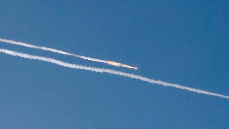 Rocket trails are seen in the sky above the Israeli coastal city of Netanya amid a fresh barrage of Iranian missile attacks on June 24, 2025. (Photo by JACK GUEZ / AFP)