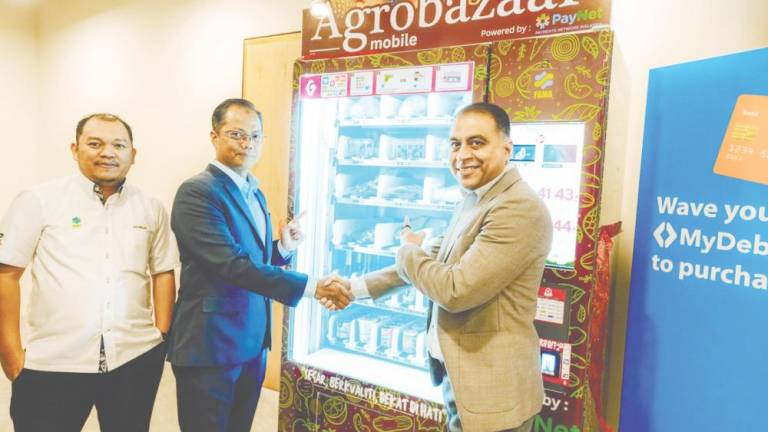 From left: Fama market institution division director Sharizan Mansor, Shahrizan and PayNet group CEO Farhan Ahmad at the launch of the grocery vending machine.