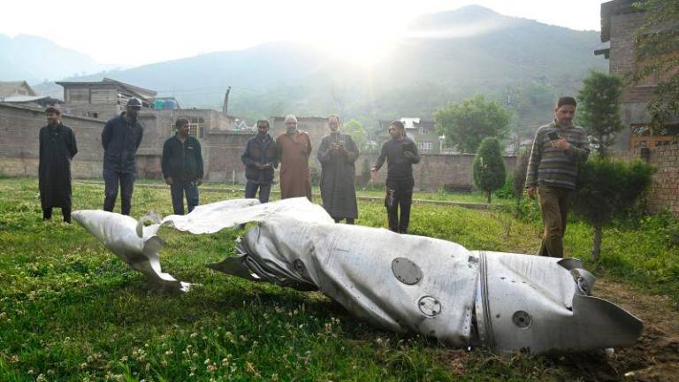 People look at a part of an aircraft in Wuyan near Indian-administered Kashmir’s main city of Srinagar on May 7, 2025. India fired missiles at Pakistani territory early on May 7, killing at least eight people, according to Pakistan, which said it had begun retaliating in a major escalation between the nuclear-armed rivals. AFPpix