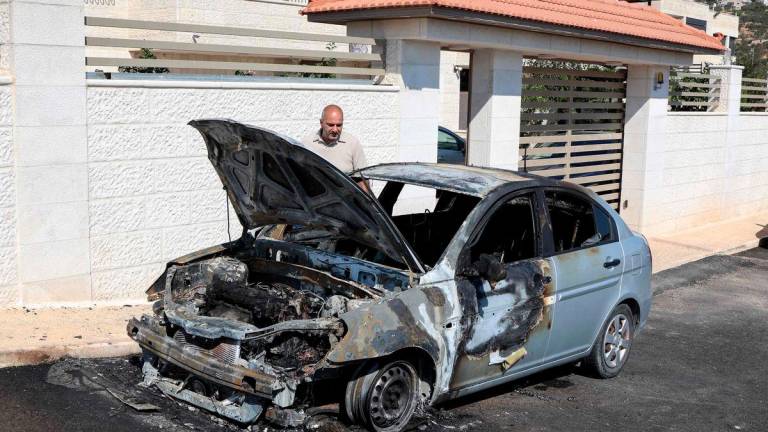A man inspects a vehicle that was reportedly torched by Israeli settlers during an overnight attack on the Palestinian Christian village of Taybeh, northeast of Ramallah in the occupied West Bank, on July 28, 2025. (Photo by Zain JAAFAR / AFP)