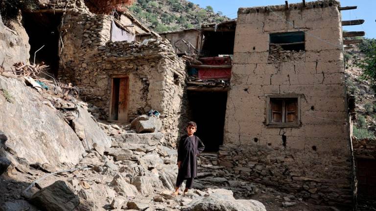A boy stands in front of houses damaged by a deadly earthquake that struck Afghanistan’s Kunar and Nangarhar provinces, at Masud village in Nurgal district, Kunar province, Afghanistan, September 4, 2025. REUTERS/Sayed Hassib TPX IMAGES OF THE DAY