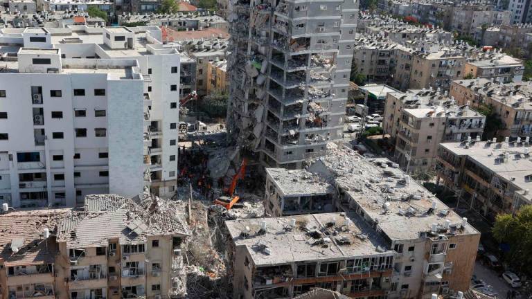 Israeli rescuers search through the rubble at the site of an overnight Iranian missile strike in Bat Yam on June 15, 2025. (Photo by GIL COHEN-MAGEN / AFP)
