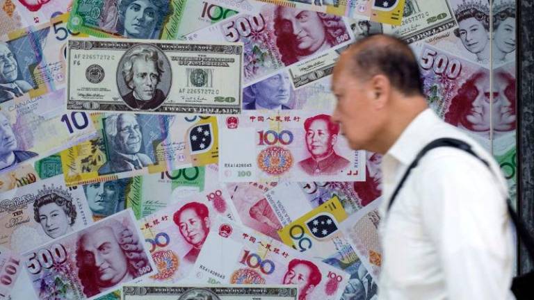 A man walks past an advertisement promoting China’s renminbi (RMB) or yuan, U.S. dollar and Euro exchange services at foreign exchange store in Hong Kong, China, August 13, 2015. REUTERSpix