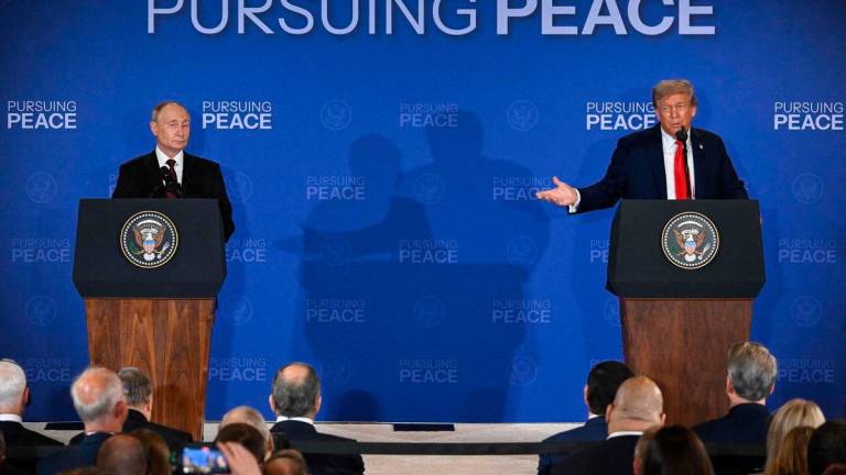 US President Donald Trump (R) gestures toward Russian President Vladimir Putin as they deliver a joint press conference after participating in a US-Russia summit on Ukraine at Joint Base Elmendorf-Richardson in Anchorage, Alaska, on August 15, 2025. (Photo by Drew ANGERER / AFP)