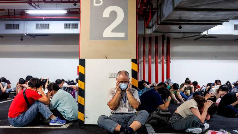 People take shelter during an air raid drill coinciding with the Kan Huang military exercises in Taipei on July 17, 2025. The annual civilian drill is being held in cities across Taiwan this week, alongside military training, to prepare the self-governed island for a potential Chinese invasion. - I-Hwa Cheng / AFP