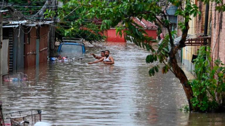 Local residents wade through flood waters after the Bishnumati River overflowed following heavy rainfall in Kathmandu - AFPpix