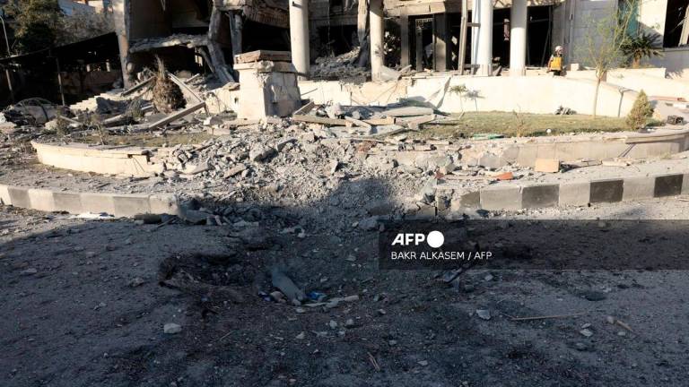 A rescuer walks inside the heavily damaged Syrian army and defence ministry headquarters complex in Damascus, following Israeli strikes on July 16, 2025. - Bakr ALkasem / AFP