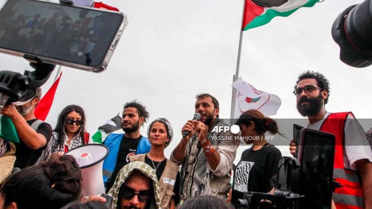 Brazilian activist Thiago Avila speaks to the crowd of pro-Palestinian activists that arrived to greet the Global Sumud Flottila at the port of the village of Sidi Bou Said on September 7, 2025. - Yassine Mahjoub / AFP