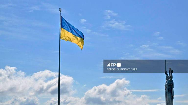 This photograph showsthe Ukrainian flag and the Motherland Monument (R) in Kyiv on August 23, 2025, a day before the Independence Day of Ukraine, amid Russian invasion in Ukraine. - AFP