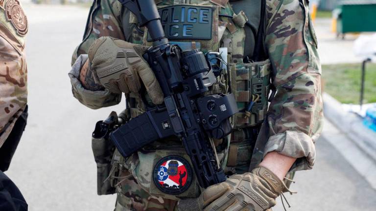 FILE PHOTO: A U.S. Immigration and Customs Enforcement officer holds a weapon during a protest outside an ICE facility, weeks after President Donald Trump ordered increased federal law enforcement presence and stepped-up immigration enforcement actions by the Department of Homeland Security, in Broadview, Illinois, U.S., September 12, 2025. REUTERS/Octavio Jones/File Photo