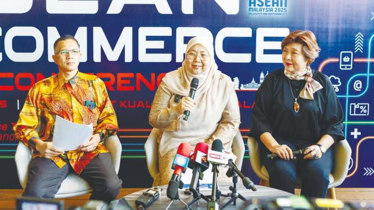 Fuziah speaking at the soft launch of the inaugural Asean E-Commerce Conference 2025. Flanking her are Tee (right) and Domestic Trade and Cost of Living Ministry deputy secretary general (consumer empowerment and management) Datuk Amran Ahmad.