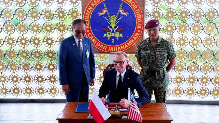 President of Poland Andrzej Duda signs a guest book during a visit to the Second Regiment of the Royal Armoured Corps at Kem Sunggala as part of his official visit to Malaysia today.- BERNAMAPIX