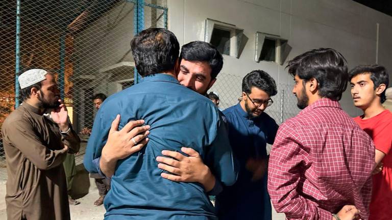 Men mourn the death of a relative, who was killed in a bomb blast at the public rally in Quetta. Reuterspix