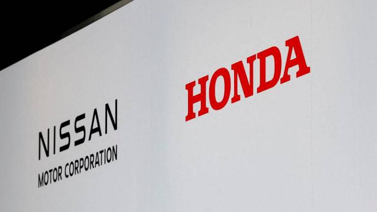 Logos of Nissan Motor Corporation and Honda are seen at a joint press conference on their merger talks, in Tokyo, Japan, December 23, 2024. Reuterspix