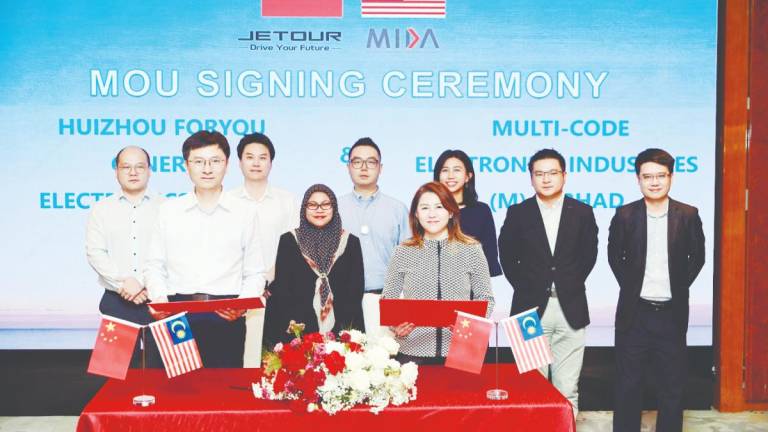 Front row: Adayo sales director Wei Song (left) and MCE Group executive director Anne Goh exchange MoU, witnessed by Mida Transportation Technology Division director Noor Suziyanti Saad (back row, third from left) and Mida Shanghai vice-consul (investment) Por Yee Yun (back row, fifth from left). Others pictured are representatives from Jetour, Adayo and MCE.
