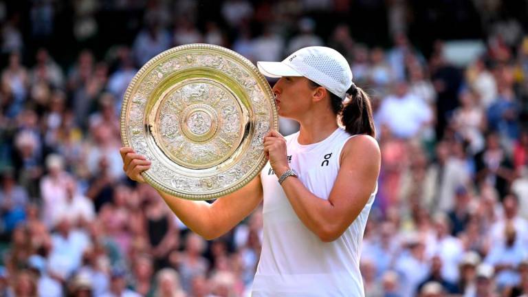 Poland’s Iga Swiatek kisses the winner’s trophy, the Venus Rosewater Dish, after winning against US player Amanda Anisimova during their women’s singles final tennis match on the thirteenth day of the 2025 Wimbledon Championships at The All England Lawn Tennis and Croquet Club in Wimbledon, southwest London, on July 12, 2025 - AFP