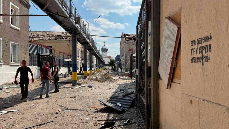Ukrainian law enforcement officers walk past damaged buildings of the Bilenkivska correctional colony following an air attack in Bilenke, Zaporizhzhia region - AFPPix