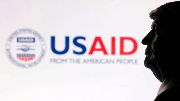 FILE PHOTO: A 3D-printed miniature model of U.S. President Donald Trump with the USAID logo in the background is seen in this illustration taken April 23, 2025. REUTERS