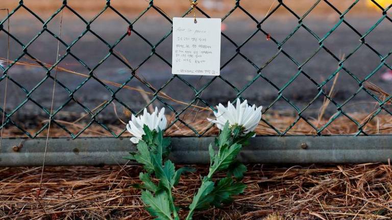 Flowers and a message of condolence laid by people working at the site where an aircraft went off the runway and crashed, are pictured at Muan International Airport in Muan - REUTERSpix