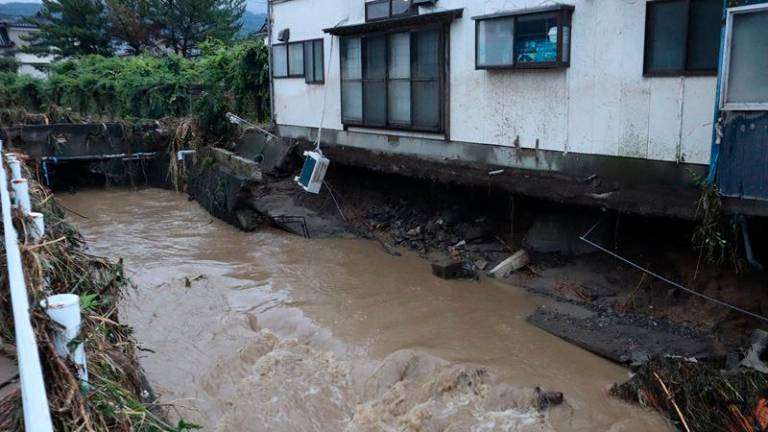 A house with a collapsed foundation is seen following heavy rains in Nikaho City, Akita prefecture on July 25, 2024. At least three people were missing in Japan on July 26, after heavy rains caused rivers to burst their banks, washing away cars and prompting several thousand locals to evacuate, authorities and media reports said. Local governments in the northern prefectures of Yamagata and Akita issued evacuation advisories to more than 200,000 people, the fire and disaster management agency said. - Japan OUT (Photo by JIJI PRESS / AFP)