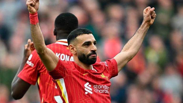 Liverpool’s Egyptian striker #11 Mohamed Salah celebrates scoring the team’s third goal from the penalty spot during the English Premier League football match between Liverpool and Southampton at Anfield in Liverpool - AFPPIX