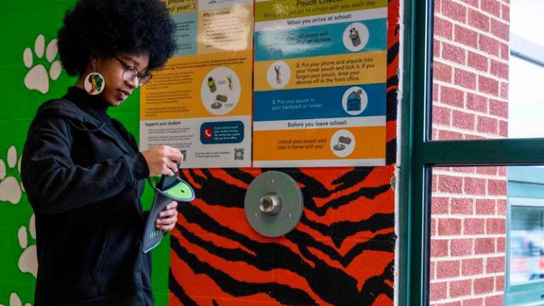 Eighth-grader Ja’ Nae Dorsey unlocks her cell phone pouch after school at Mark Twain Middle School in Alexandria, Virginia - AFPPIX