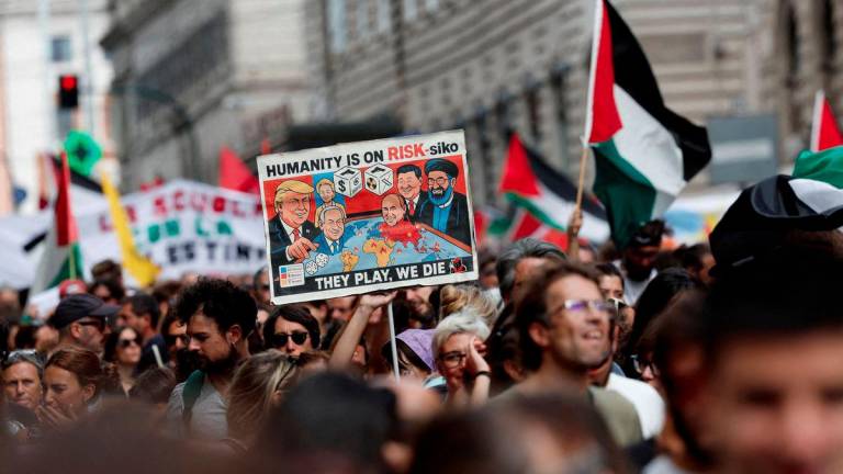 A pro-Palestinian demonstrator carries a placard during a nationwide strike called by the USB union, with the slogan Let's Block Everything, in solidarity with Gaza and calling for a halt to arms shipments to Israel, in Rome, Italy, September 22, 2025. - REUTERSPIX
