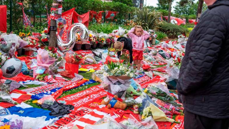 Well-wishers leave flowers, scarves and shirts at a memorial set up close to Anfield football ground for their Portuguese forward Diogo Jota in Liverpool, north-west England July 4, 2025 - AFP