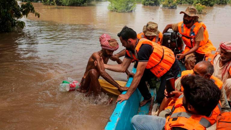 A rescuer pulls a flood-affected man on board a boat after the flood in the Chenab river, in Muzaffargarh in Punjab province on September 6, 2025. Water has gushed into the eastern province, Pakistan’s breadbasket and home to about half of its 255 million people, with three transboundary rivers swelling beyond their banks. (Photo by Shahid Saeed MIRZA / AFP)