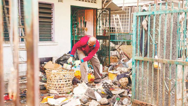 A council member sorting through piles of trash at the premises. – CHANDRA SAGARAN/THESUN