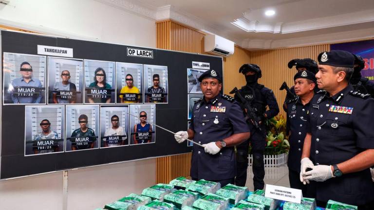 Pengarah Jabatan Siasatan Jenayah Narkotik Bukit Aman, Datuk Hussein Omar Khan (kiri) menunjukkan gambar suspek yang ditahan berhubung sindiket pengedaran dadah antarabangsa berjaya ditumpaskan dalam empat siri serbuan serentak di Johor dan Lembah Klang pada 21 Julai lepas, dengan rampasan dadah bernilai lebih RM2 juta, Ibu Pejabat Polis Daerah Muar hari ini - BERNAMA