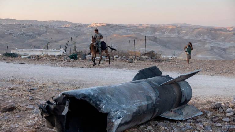 A man rides a horse next to the remains of an Iranian missile that fell an outpost near the Israeli settlement of Tekoa in the occupied West Bank, on 29 June 2025, in the aftermath of the 12-day war between Israel and Iran. - Menahem Kahana / AFP