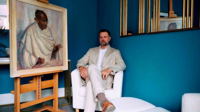 Caspar Leighton, great-nephew of British-American artist Clare Leighton, poses with a painting by his great-aunt of Indian independence leader Mahatma Gandhi at Bonhams auction house in London on June 9, 2025.
