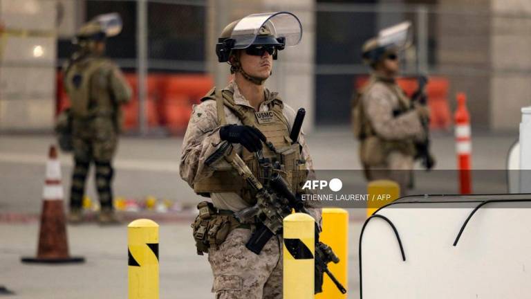 US Marines stand guard as about ten protesters demonstrate outside the Metropolitan Detention Center following protests sparked by federal immigration operations in Los Angeles on June 14, 2025. - ETIENNE LAURENT / AFP