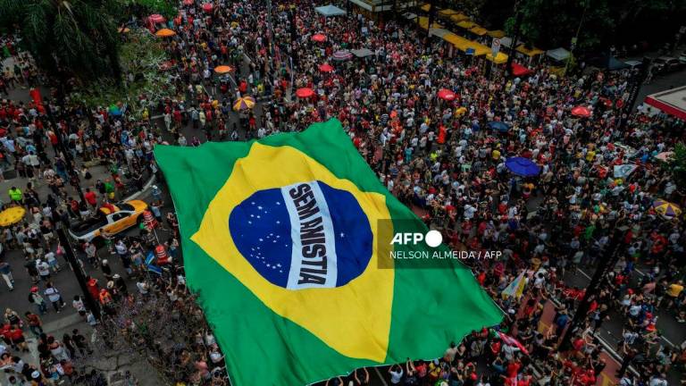 This aerial view shows people carrying a huge Brazilian flag reading No amnesty during a protest against a constitutional amendment known as the Shielding Project, which requires Congress to authorize any criminal charges against deputies and senators through a secret vote, in Sao Paulo, Brazil, on September 21, 2025.- AFP