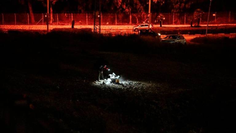 An Israeli police officer inspects the remains of a projectile after a rocket was fired from Lebanon and landed in Israel, amid cross-border hostilities between Hezbollah and Israel, in Haifa, Israel, October 7, 2024. - REUTERSPIX