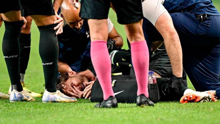 Tottenham Hotspur’s James Maddison (C) reacts before being stretchered off the pitch, after suffering an injury. AFPPix