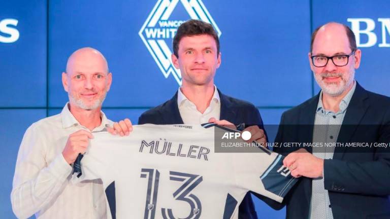 Thomas Müller poses with his jersey alongside Jesper Sørensen (L) Whitecaps FC head coach and Axel Schuster, Whitecaps FC CEO &amp; sporting director during a press conference at TELUS Garden on August 14, 2025 in Vancouver, British Columbia. - Elizabeth Ruiz Ruiz/Getty Images/AFPPIX
